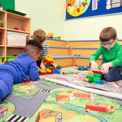 Das Bild zeigt Kinder auf ihrem Spielteppich