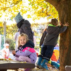 Das Bild zeigt spielende Kinder im Außengelände der Kita Hübenbusch