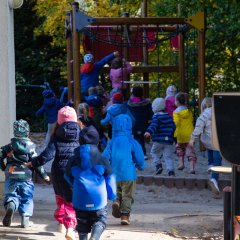 Das Bild zeigt Kinder, die auf ein Klettergerüst zulaufen