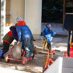 Das Bild zeigt Kinder auf ihren Dreirädern